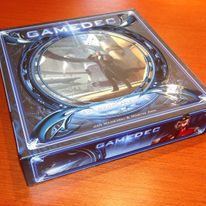 Pudełko gry planszowej "Gamedec". Dyrektorem artystycznym przedsięwzięcia był Tomek Maroński, ilustracje gadżetów i postaci wykonał Łukasz Matauszek, zaś autorem mechaniki był Jan Madejski.