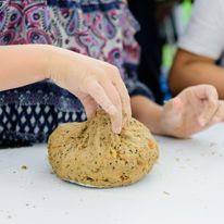 Uczestnicy własnoręcznie łączą mąki, wodę, dodatki...